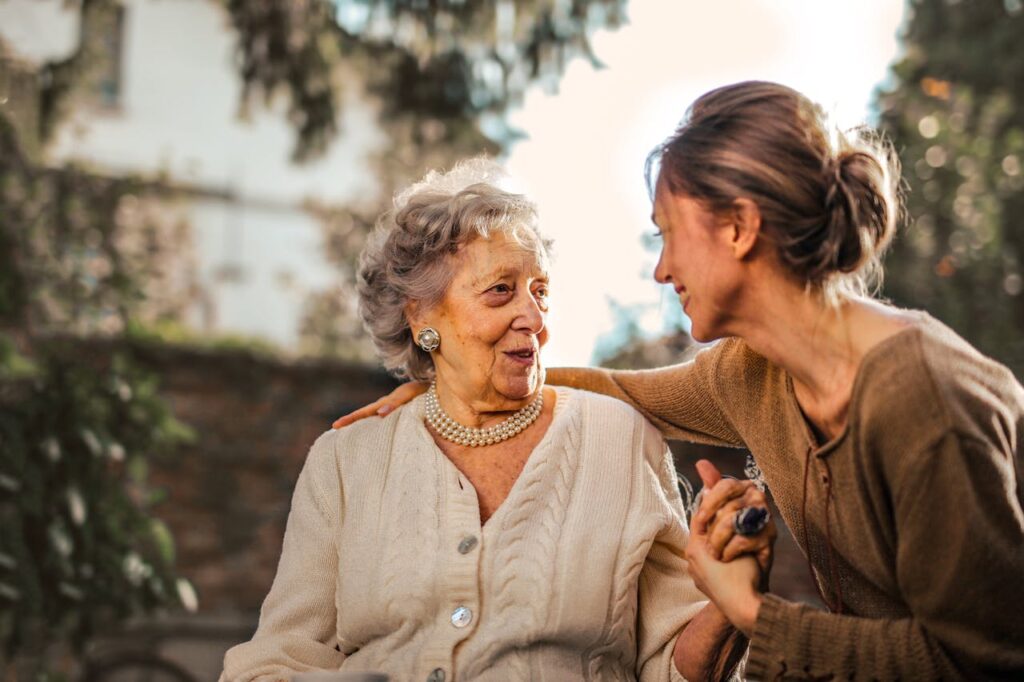 pexels photo 3768131 Elderly woman and adult daughter share a joyful, affectionate moment in a sunny garden.